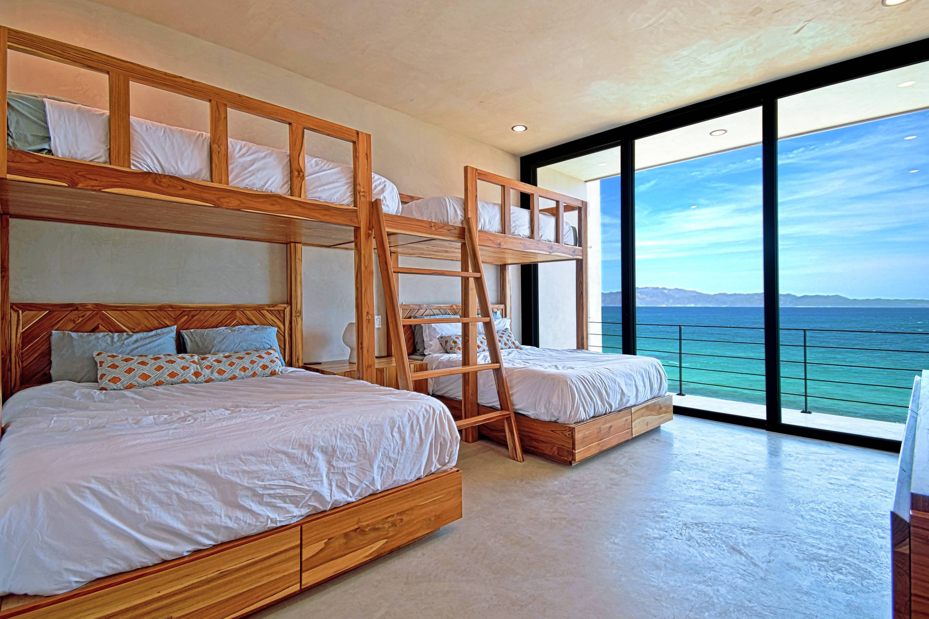 The teak built-in bunks in the second bedroom, glass wall onto the bay.