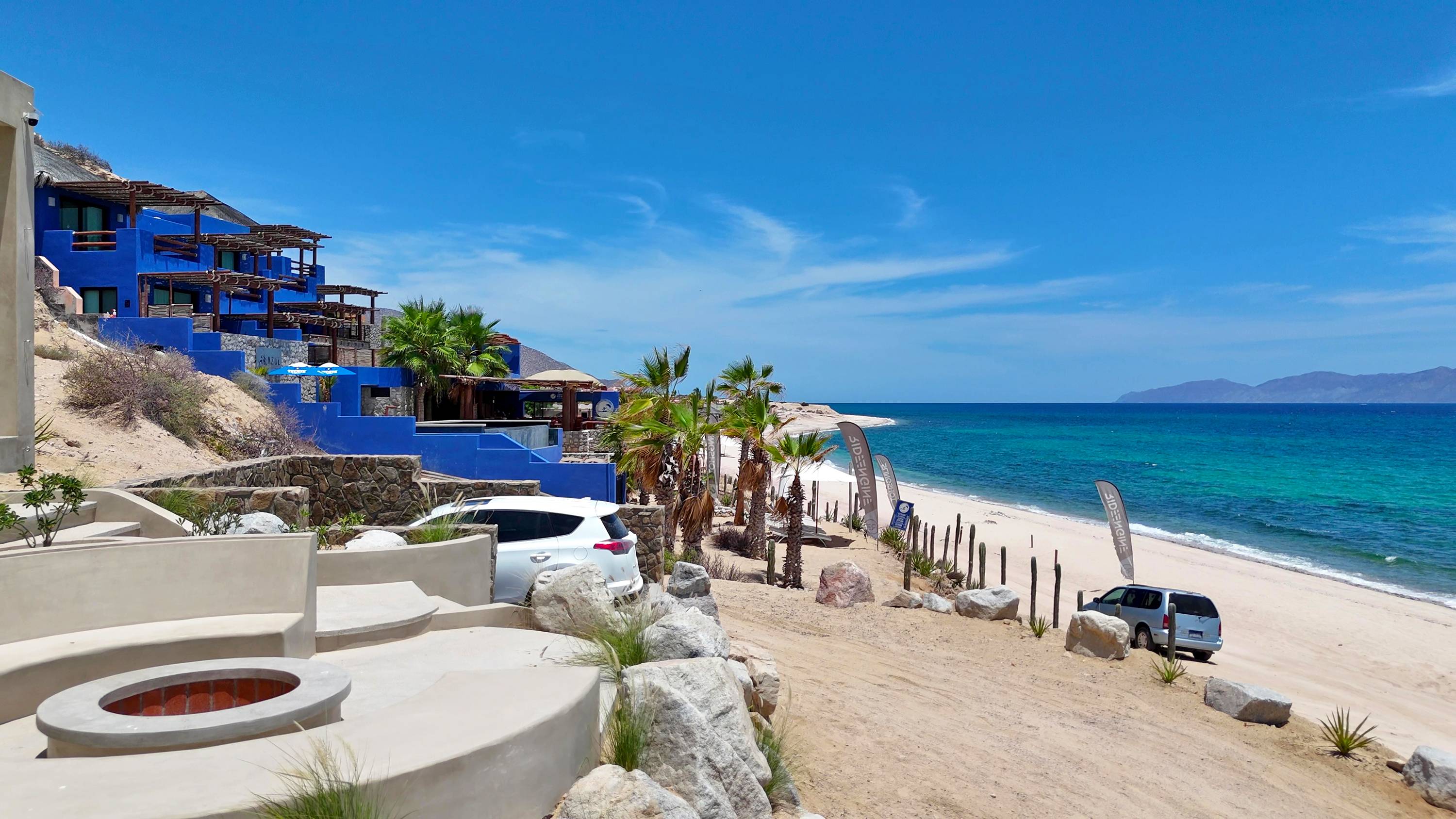 The fire pit terrace in the foreground, the beach and the bay beyond.