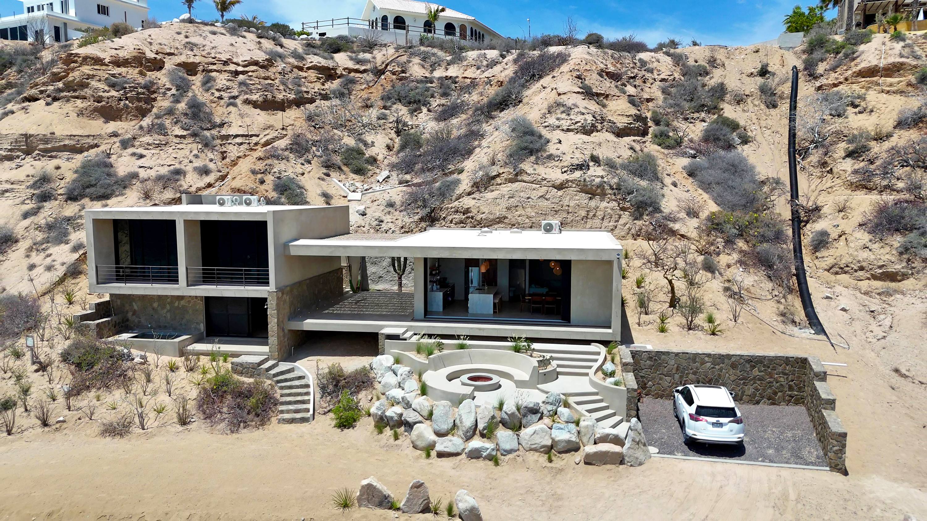 The house from the air, two volumes with the patio between them, facing the beach.