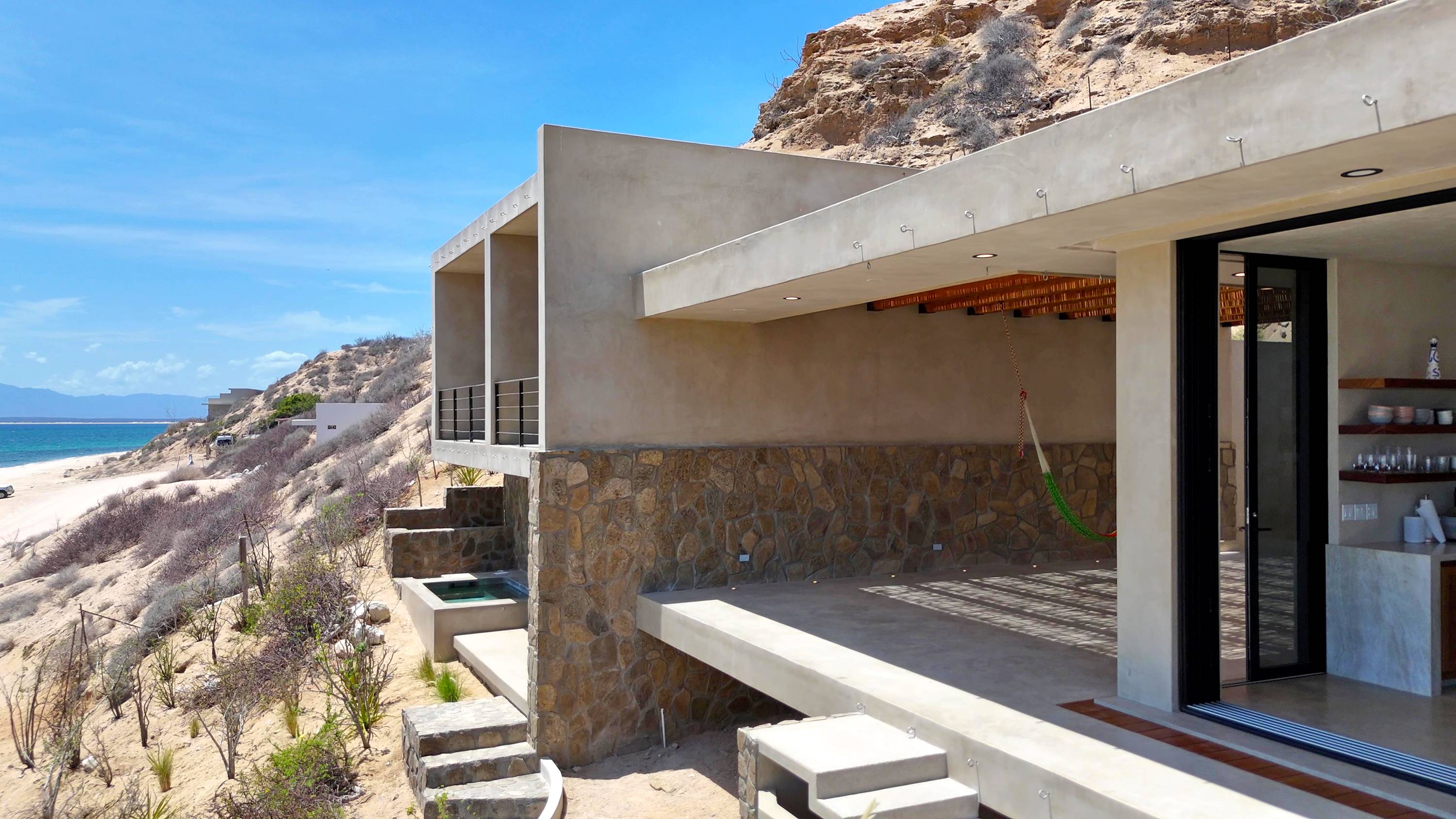 The lower level of the house from the air, pool terrace and the beach beyond.