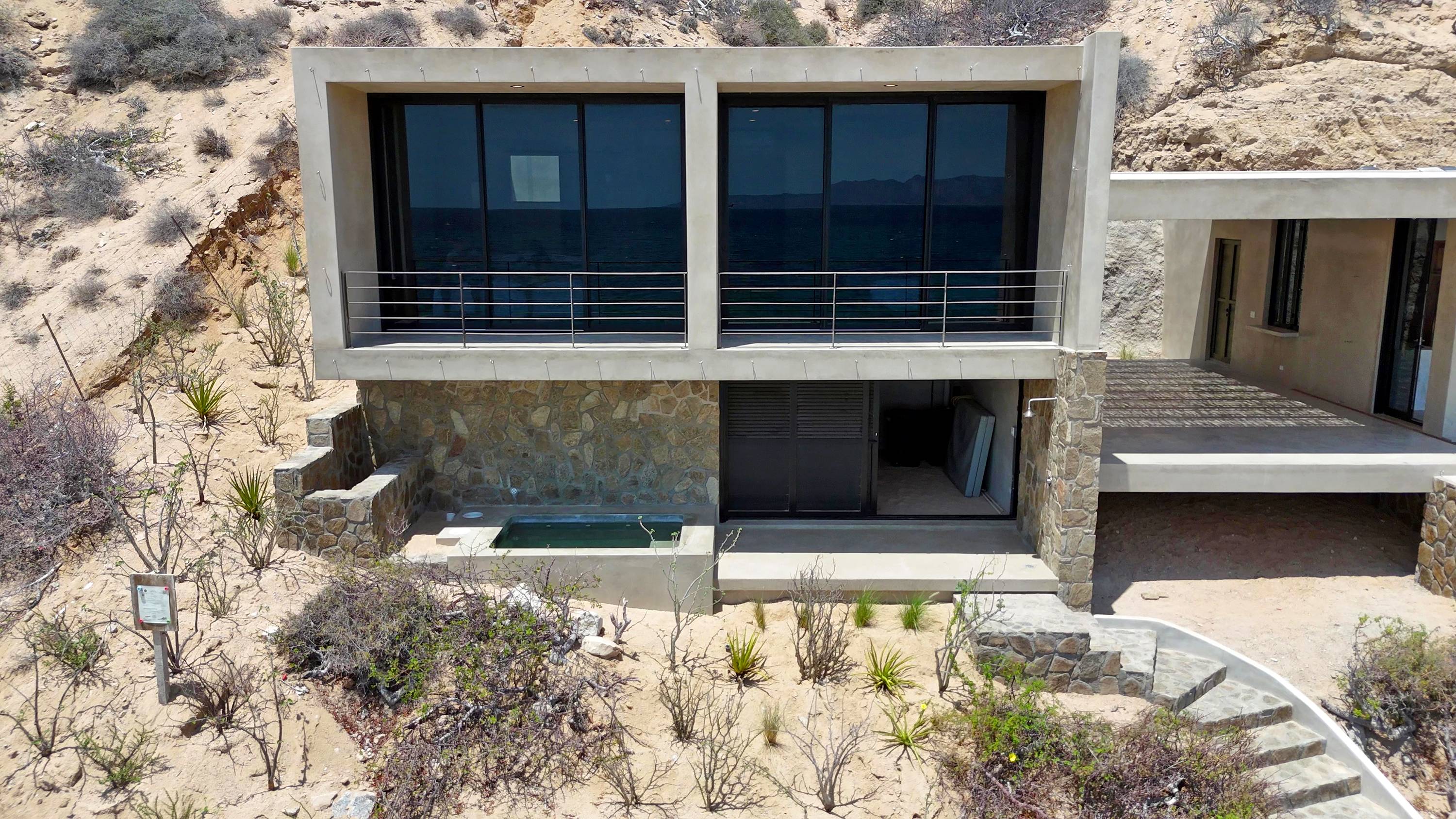 The bedroom volume from behind, gear storage open underneath and the plunge pool at the left.