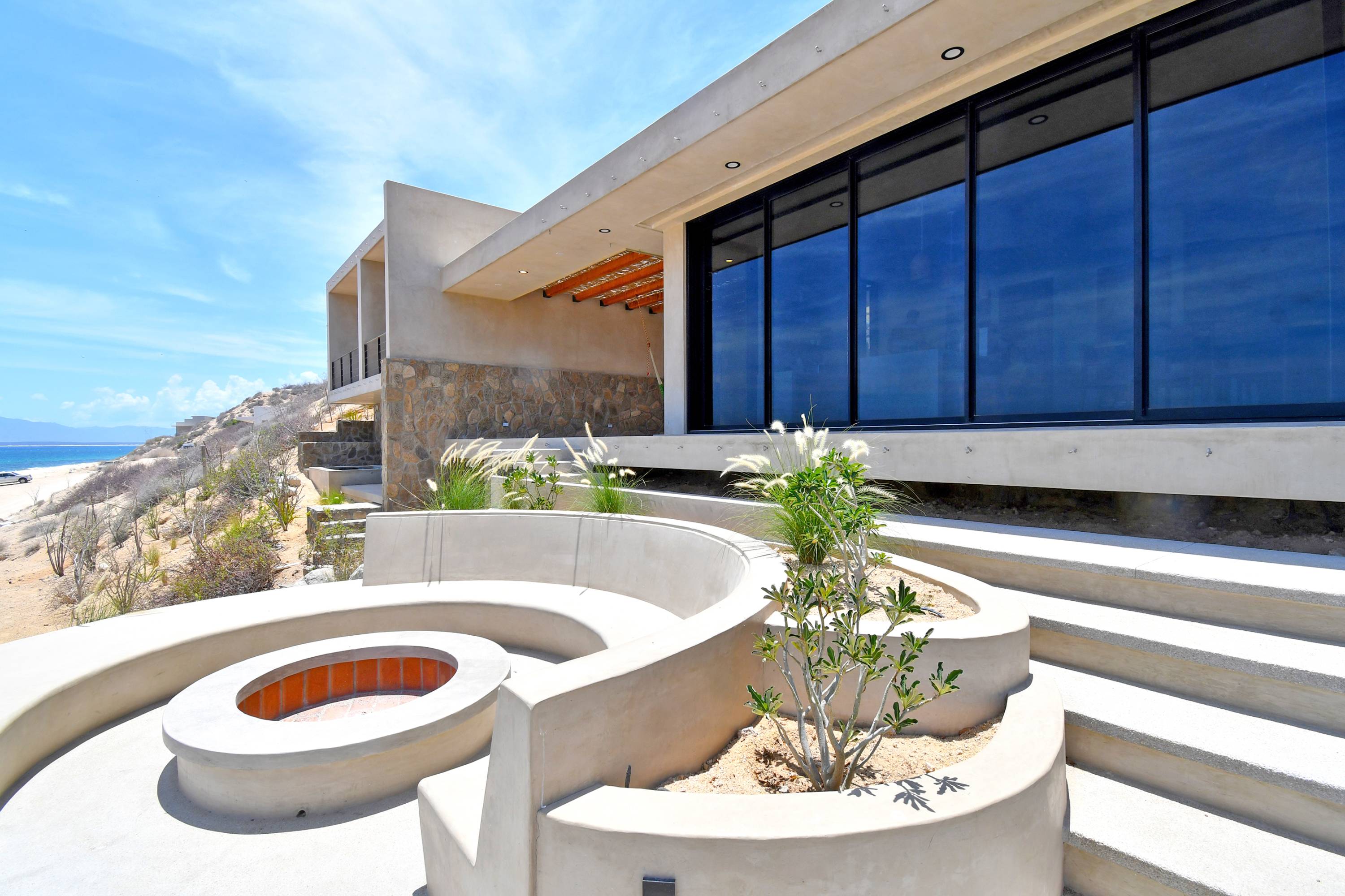 The front of the house, windows running the length of the living side.