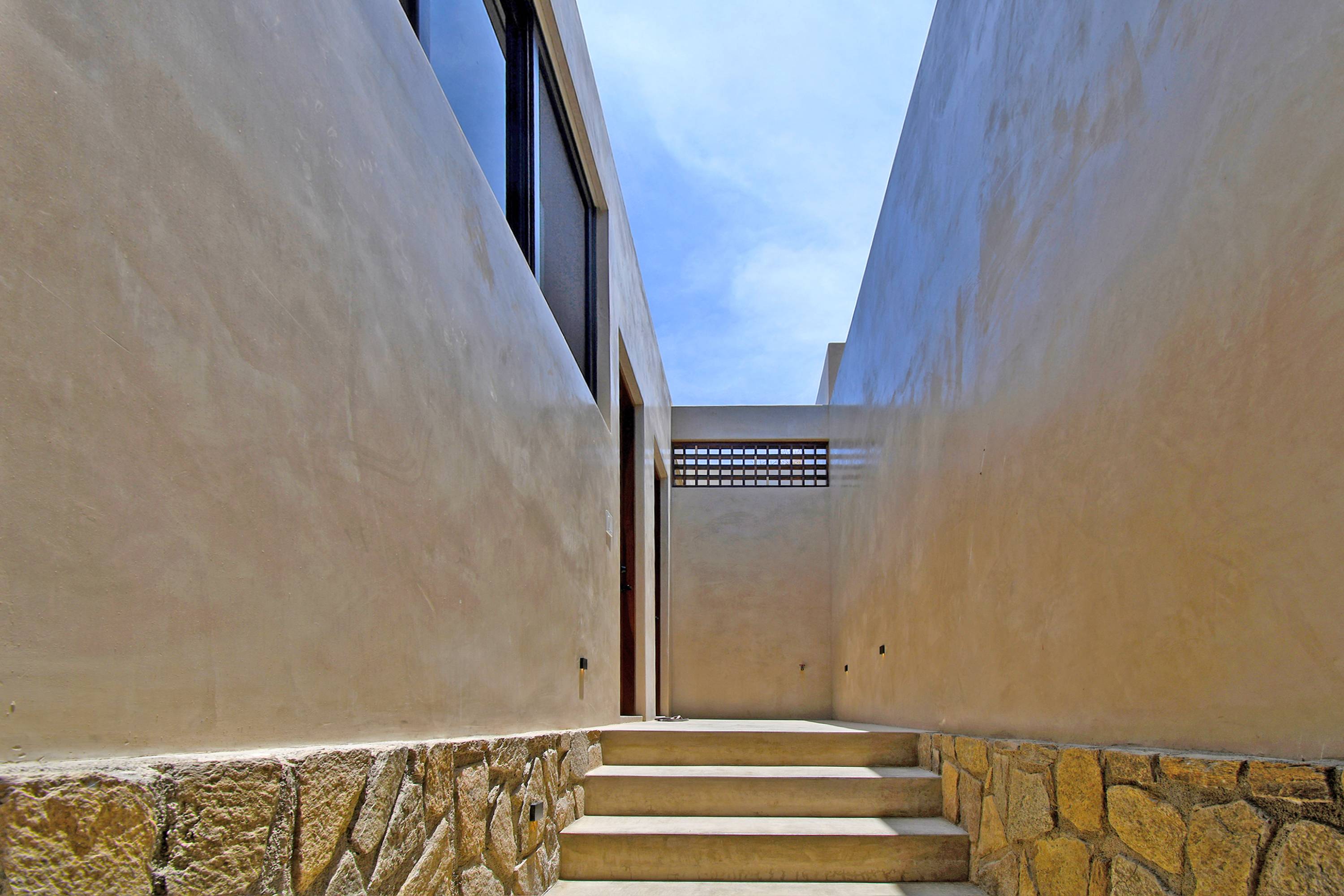 The open-air passage up to the bedrooms, running between the walls of the house.