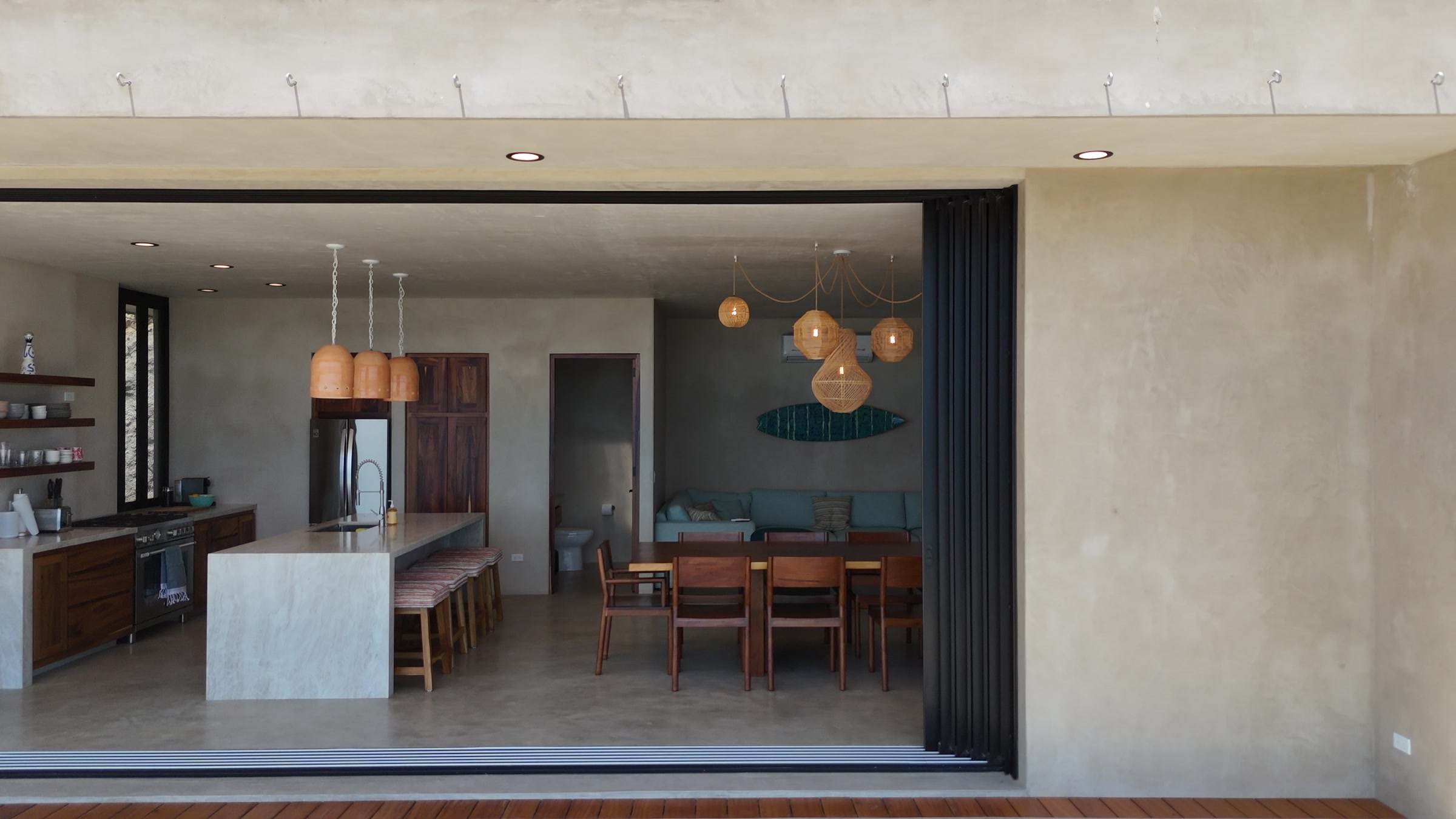 The living side with its glass front slid away, kitchen island and dining table inside.