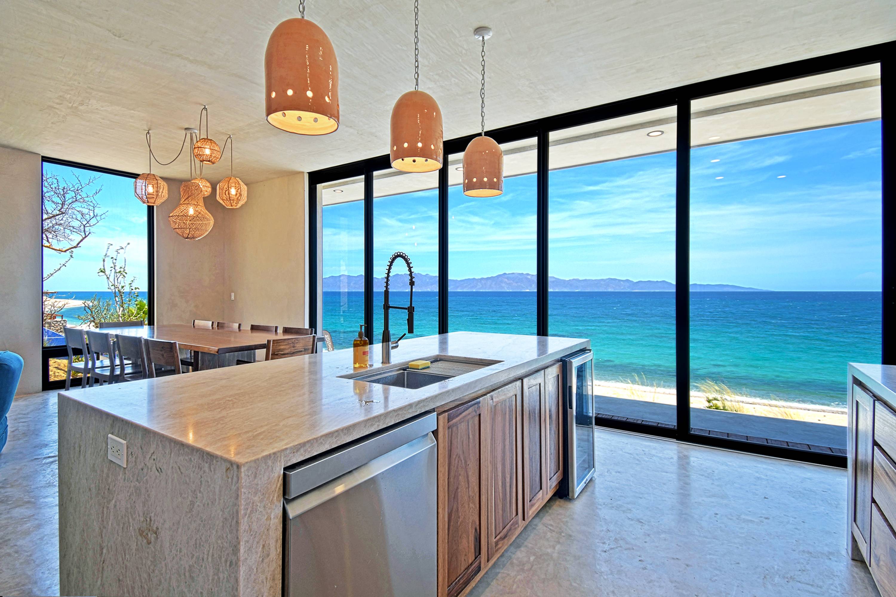 The kitchen island with the bay through the glass behind it.
