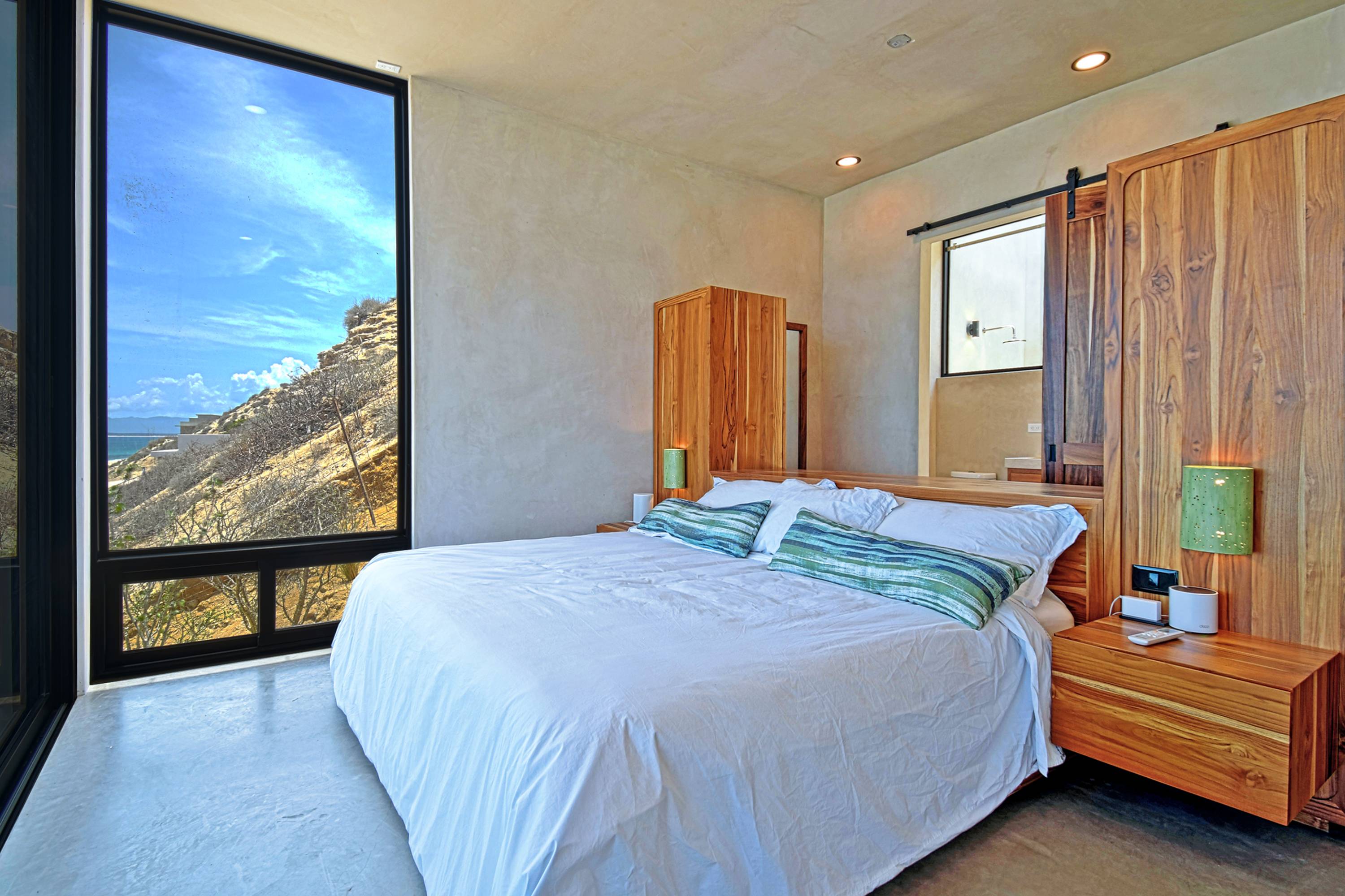 The master bed, window onto the hillside at the left.