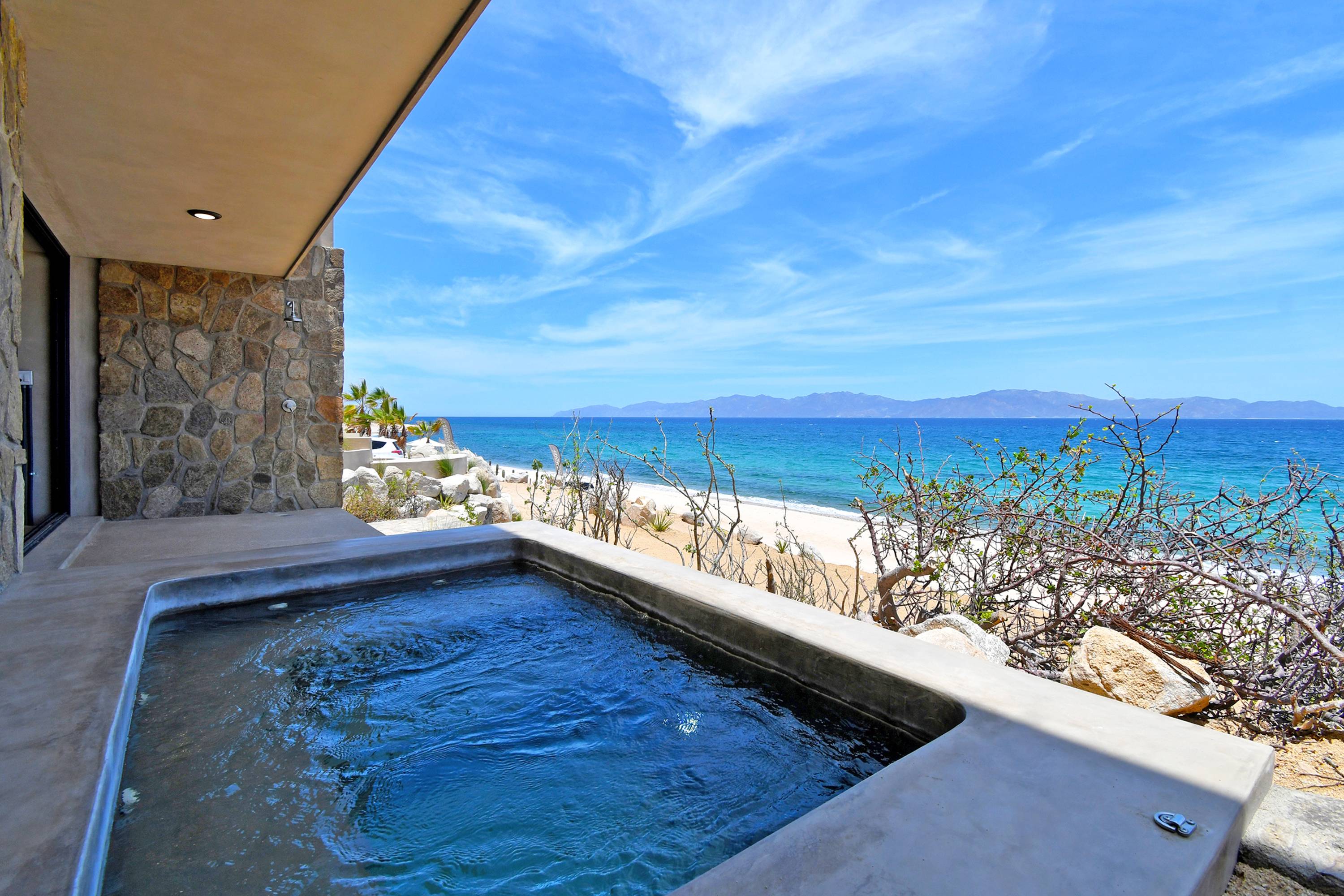 The plunge pool set against the stone wall, looking out over the bay.